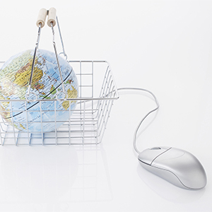still life of globe in shopping basket and computer mouse