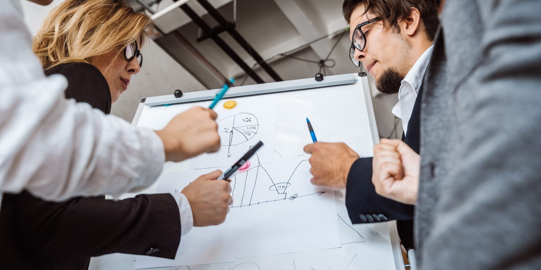Businesspeople with whiteboard discussing strategy in a meeting